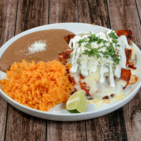 La Mesa Modern Mexican enchiladas with rice, refried beans, cheese, sour cream, cilantro, and lime.